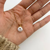 Elegant 18k Gold Diamond Necklace, in round cut, and prong setting, resting in an open palm. Solitaire diamond pendant as anniversary present or birthday gift.