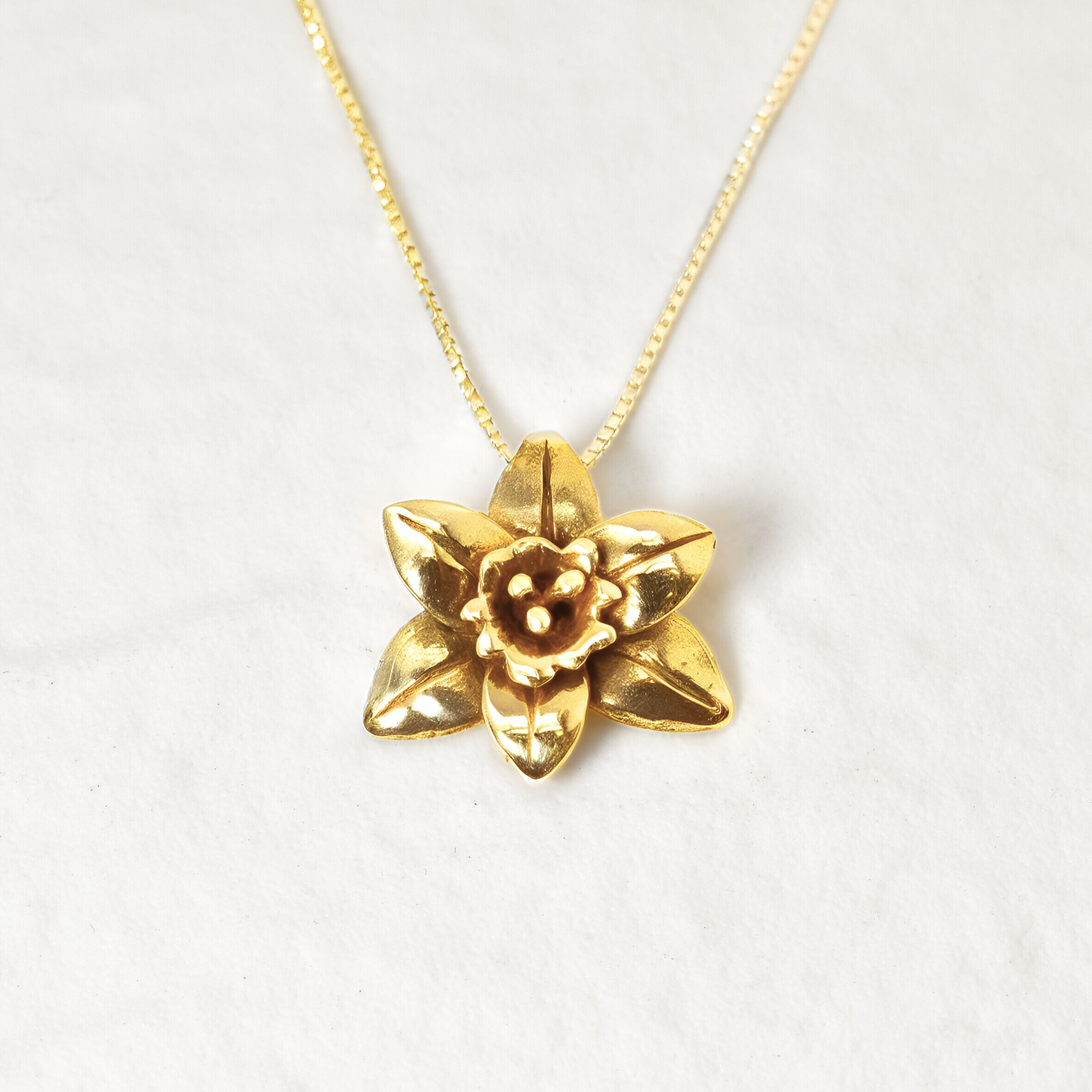 Yellow gold plated necklace with poinsettia flower design. Dainty floral pendant ideal as personalized gift, and good for layering necklaces. Gold charm pendant for everyday wear.