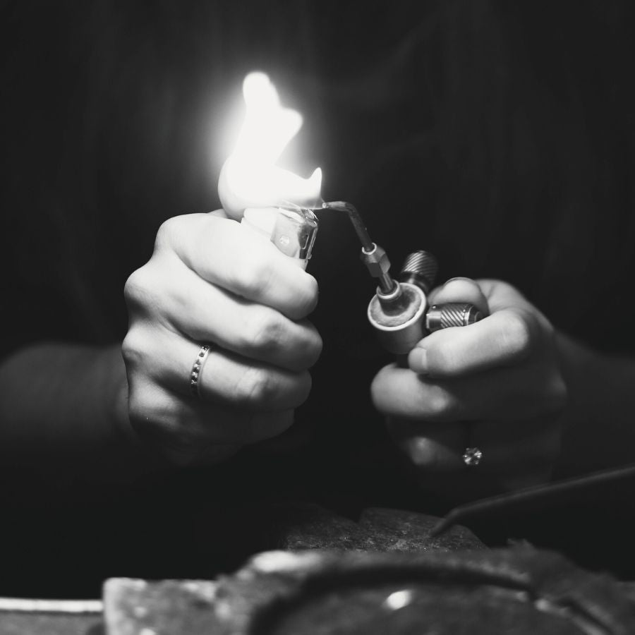 Black and white image of hands holding a lighter with flame.