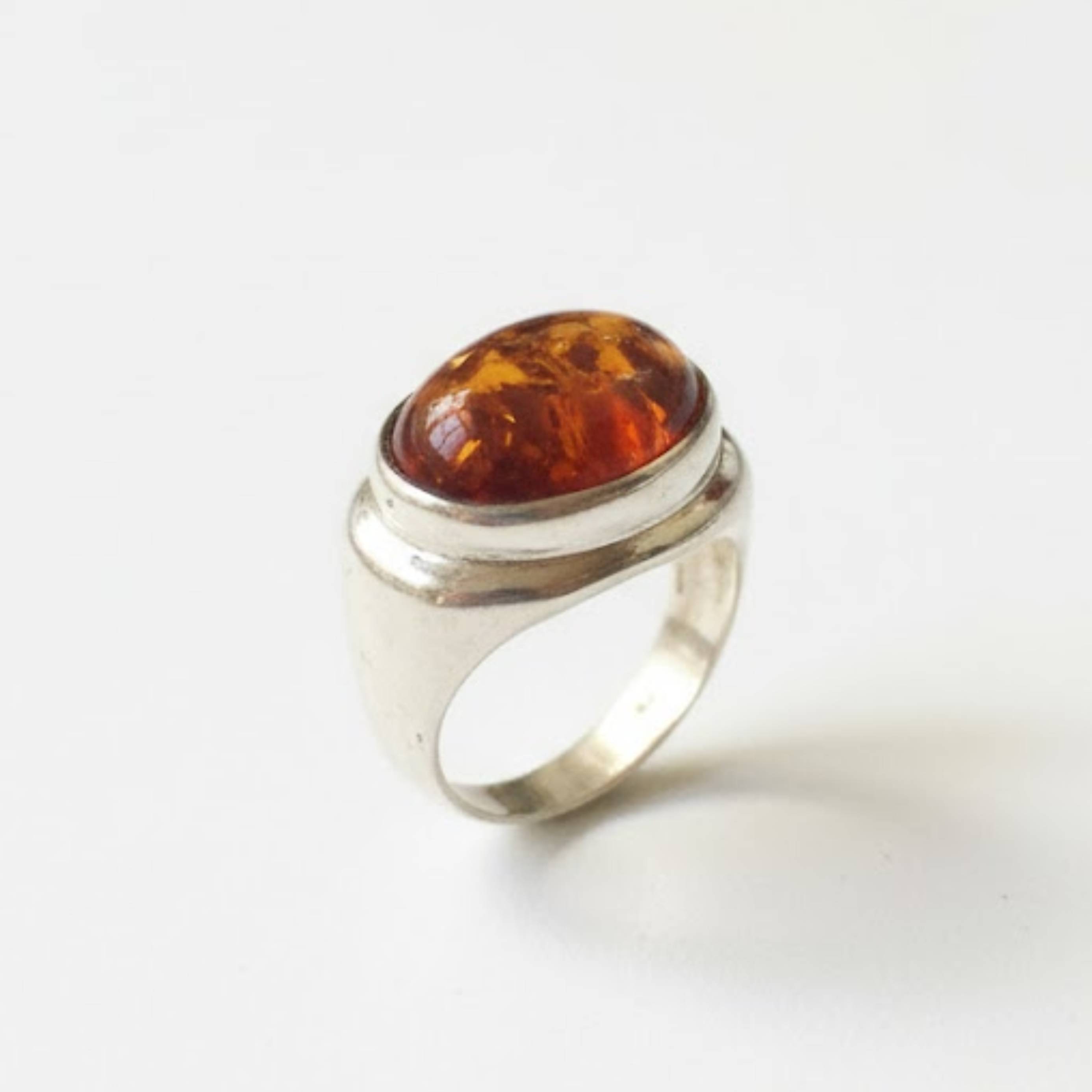 A cozy mountain cabin nestled among snow-covered pines, with smoke rising from the chimney and a clear blue sky overhead.