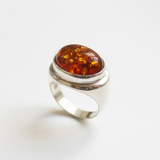 A vibrant sunset over a serene lake, with trees silhouetted against the colorful sky.