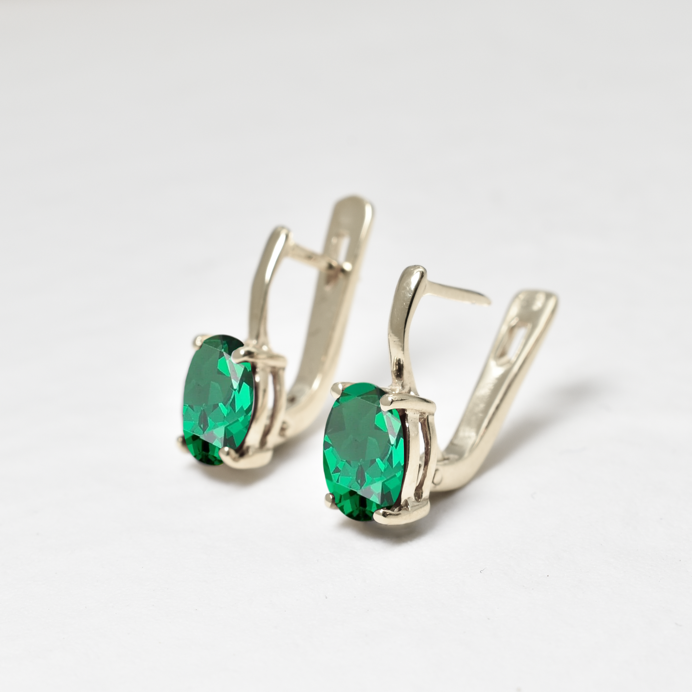 Elegant Sterling Silver Emerald Earrings with Oval Created Green Emeralds, perfect for May birthdays and special occasions.
