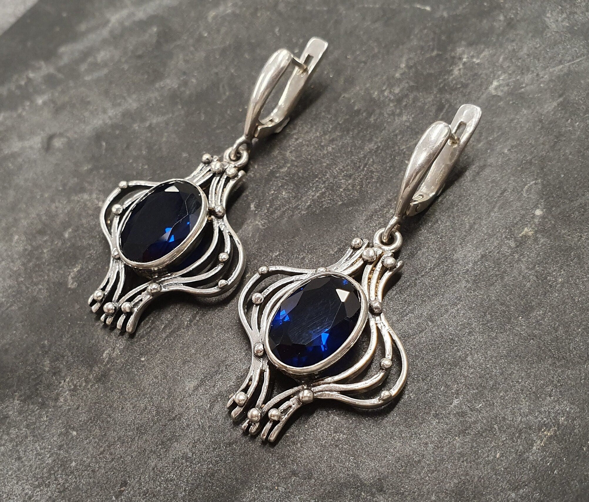 Created Sapphire Earrings made in 925 Sterling Silver with Oval Created Blue Sapphire in Bezel setting, September Birthstone gift idea, symbolizes sincerity, truth, and faithfulness, ideal for everyday wear and perfect for birthday gifting and special occasions.