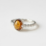 A serene landscape featuring a tranquil lake surrounded by lush green trees, reflecting the calm sky above.