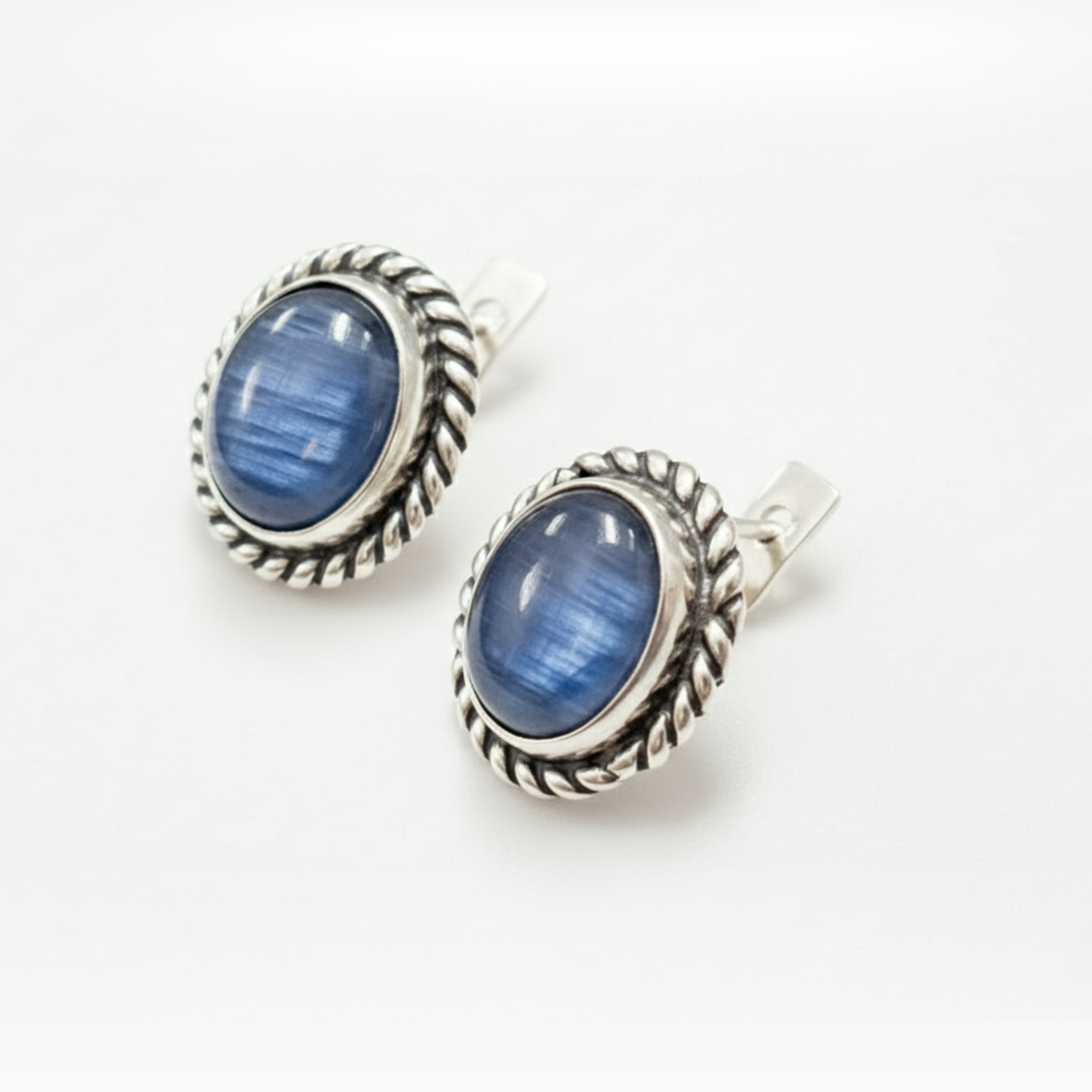 Artisan-made silver earrings with deep blue kyanite cabochons, classic vintage jewelry design.