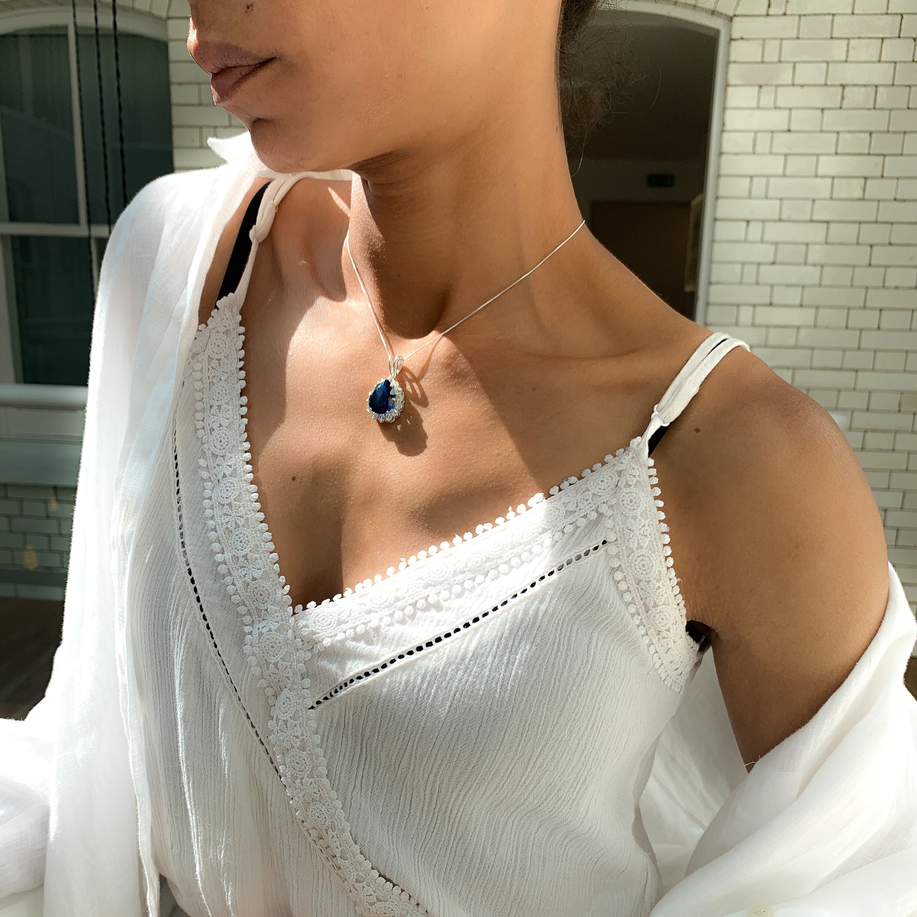 Elegant sapphire pendant in 925 sterling silver, prong-set with a pear-shaped blue sapphire, perfect for birthdays and special occasions.