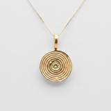 Close-up natural peridot bezel pendant in 18k gold vermeil, vibrant green August birthstone for everyday wear