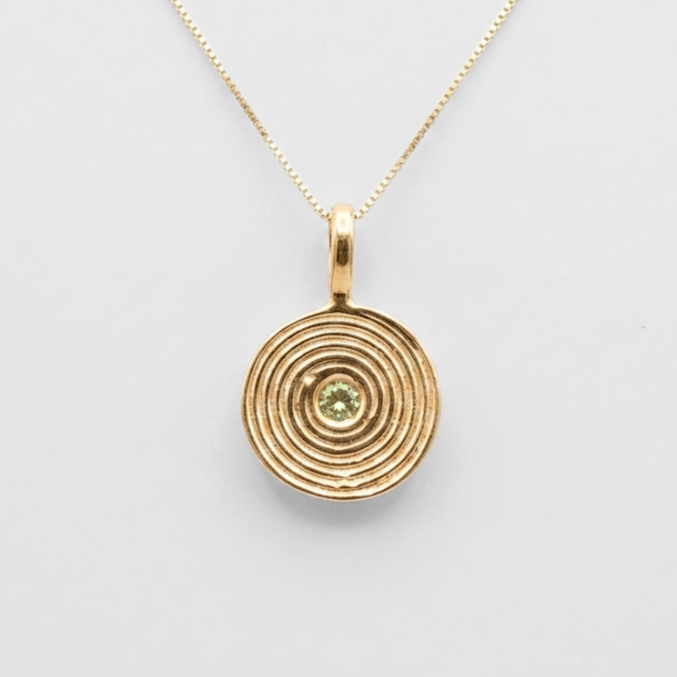 Close-up natural peridot bezel pendant in 18k gold vermeil, vibrant green August birthstone for everyday wear