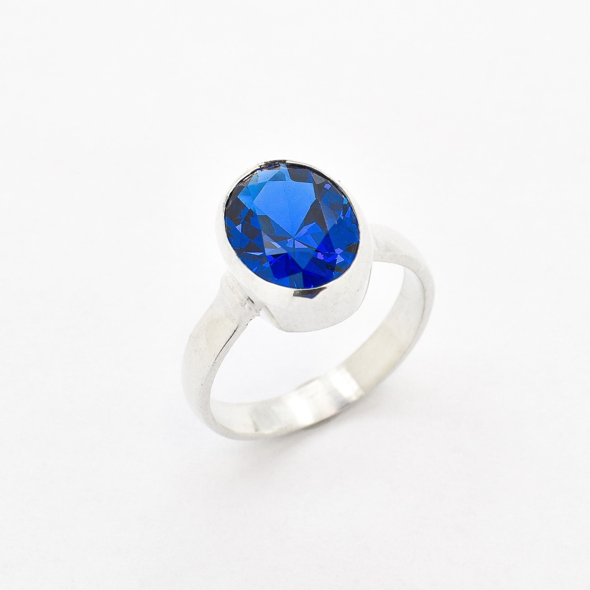 Created Sapphire Ring made in 925 Sterling Silver with Oval Created Blue Sapphire in Bezel setting, September Birthstone gift idea, symbolizes sincerity, truth, and faithfulness, ideal for everyday wear and perfect for birthday gifting and special occasions.