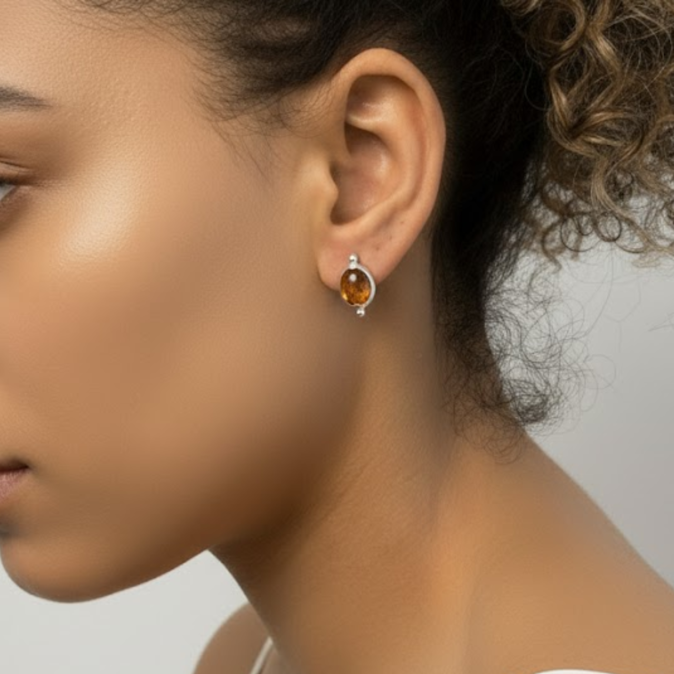 A vibrant sunset casting golden hues over rolling hills dotted with blooming wildflowers.