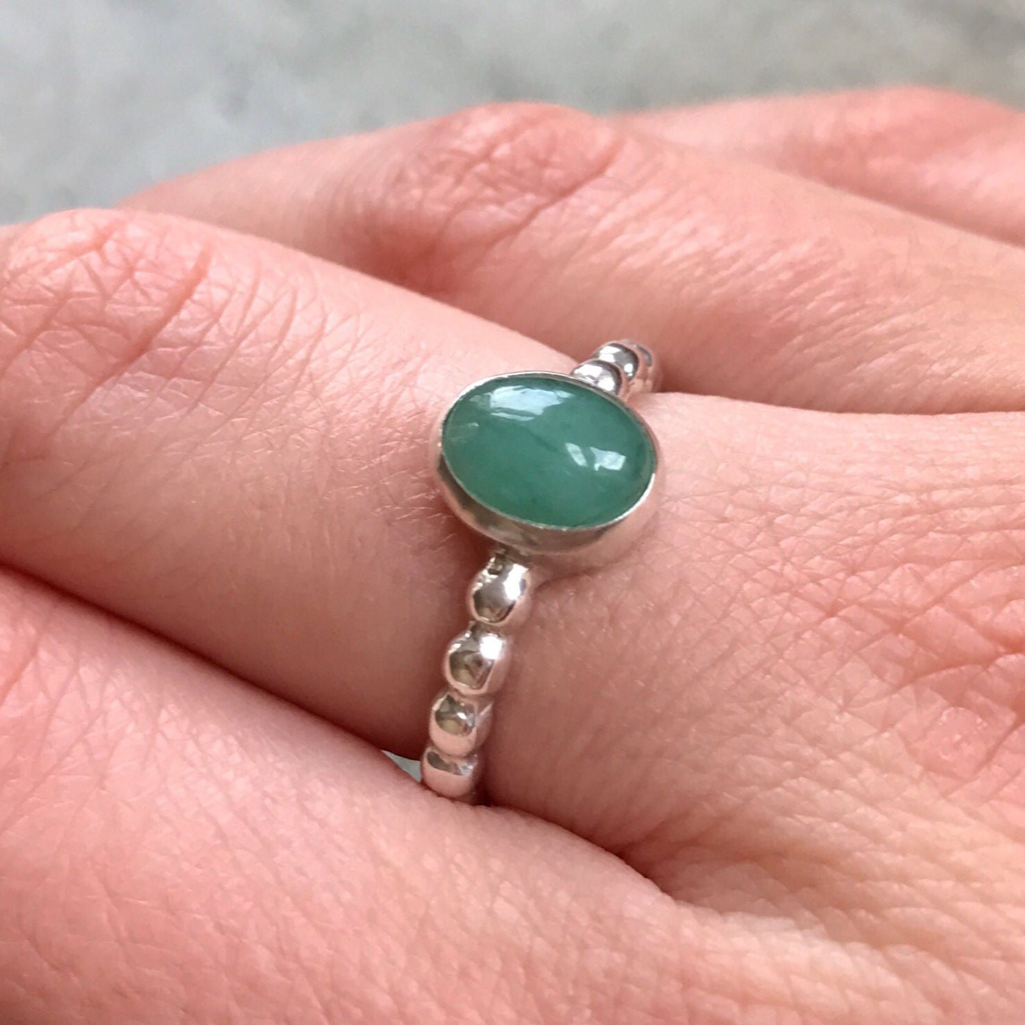 Sterling Silver Natural Emerald Ring, oval gemstone in bezel setting, symbolizes growth and healing, perfect for special occasions.