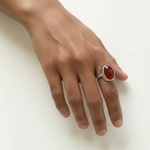 An elegant silver statement ring with a carnelian gemstone, beautifully worn on the hand.