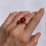 A beautifully crafted gemstone ring resting on a soft velvet pillow, showcasing its intricate design and brilliance.