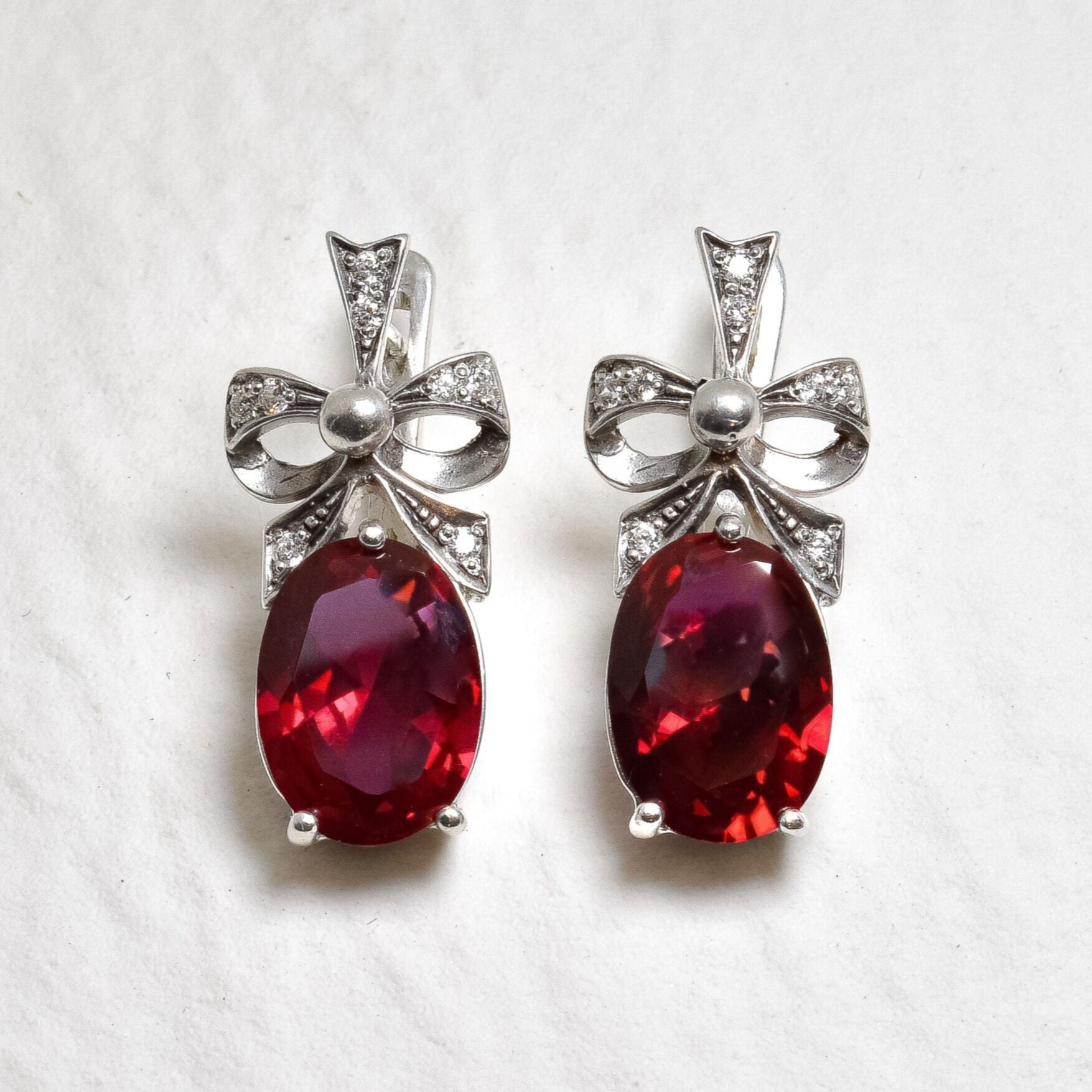 Created Ruby Earrings made in 925 Sterling Silver with Oval Created Red Ruby in Solitaire with Accents setting, July Birthstone gift idea, symbolizes nobility, purity, and passion, ideal for everyday wear and perfect for birthday gifting and special occasions.