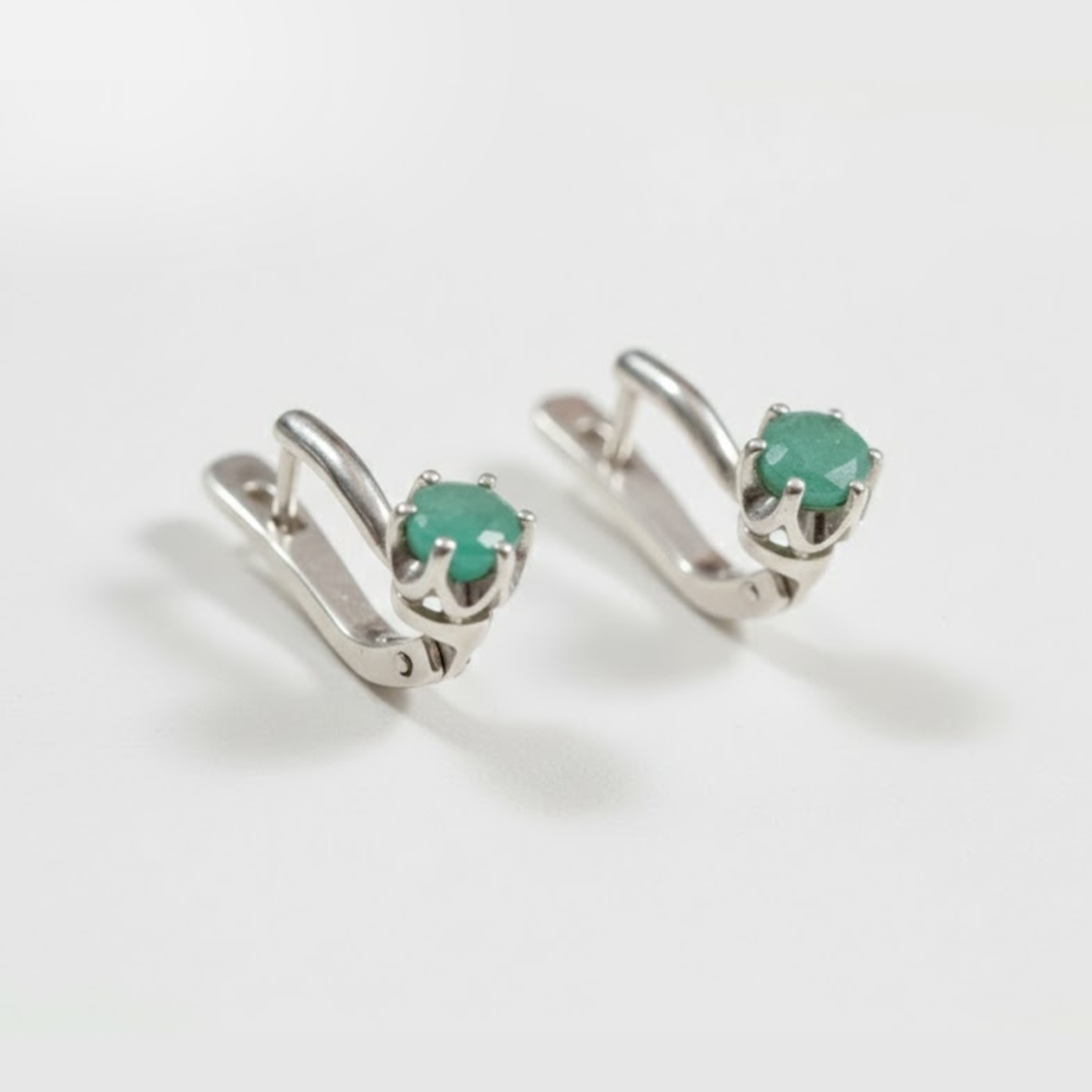 Chic sterling silver earrings with natural emeralds, celebrating May's birthstone—perfect for enhancing any outfit and special moments.