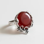 A young boy leaps joyfully on a trampoline, looking up at the clear blue sky streaked with fluffy white clouds.