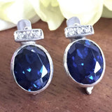 Created Sapphire Earrings made in 925 Sterling Silver with Oval Created Blue Sapphire in Bezel setting, September Birthstone gift idea, symbolizes sincerity, truth, and faithfulness, ideal for everyday wear and perfect for birthday gifting and special occasions.