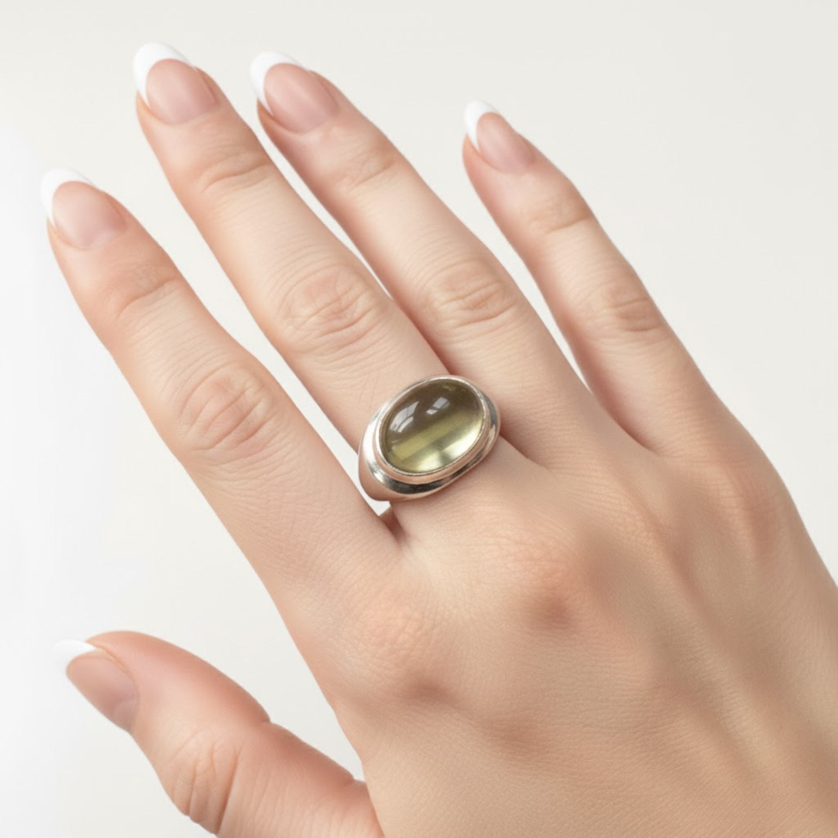 A panoramic view of a serene lake surrounded by lush green hills under a clear blue sky, reflecting the landscape.