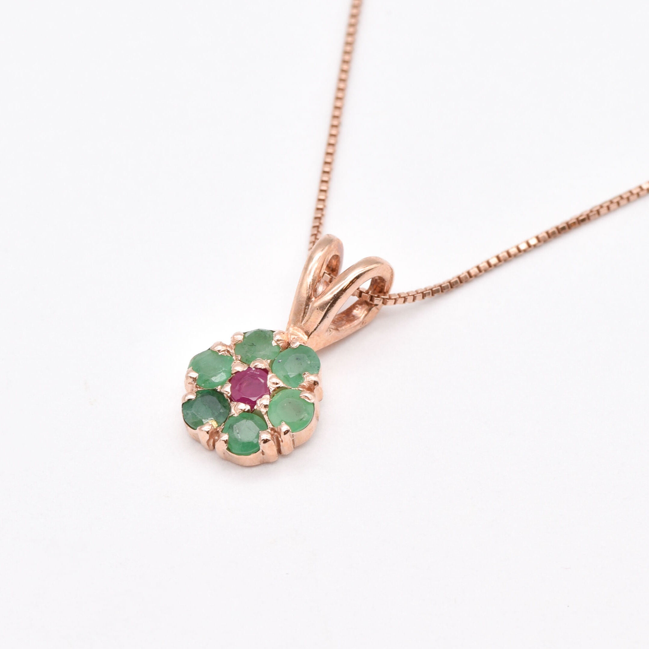Charming rose gold vermeil pendant adorned with a vibrant natural emerald cluster, representing growth and harmony.