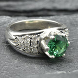 Stunning cluster ring in 925 Sterling Silver, adorned with a round created green emerald, perfect for May-born celebrations.