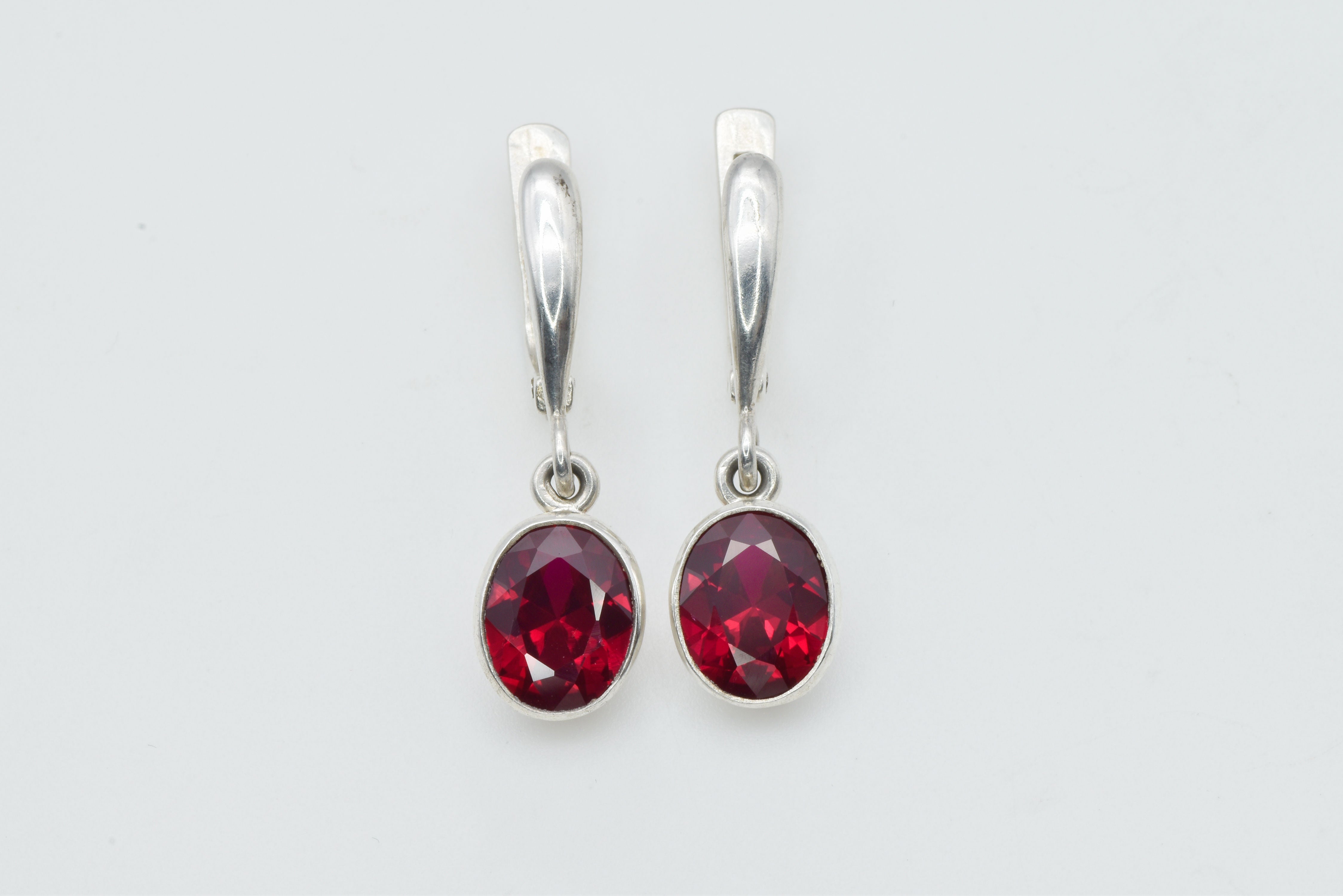 Created Ruby Earrings made in 925 Sterling Silver with Oval Created Red Ruby in Bezel setting, July Birthstone gift idea, symbolizes nobility, purity, and passion, ideal for everyday wear and perfect for birthday gifting and special occasions.