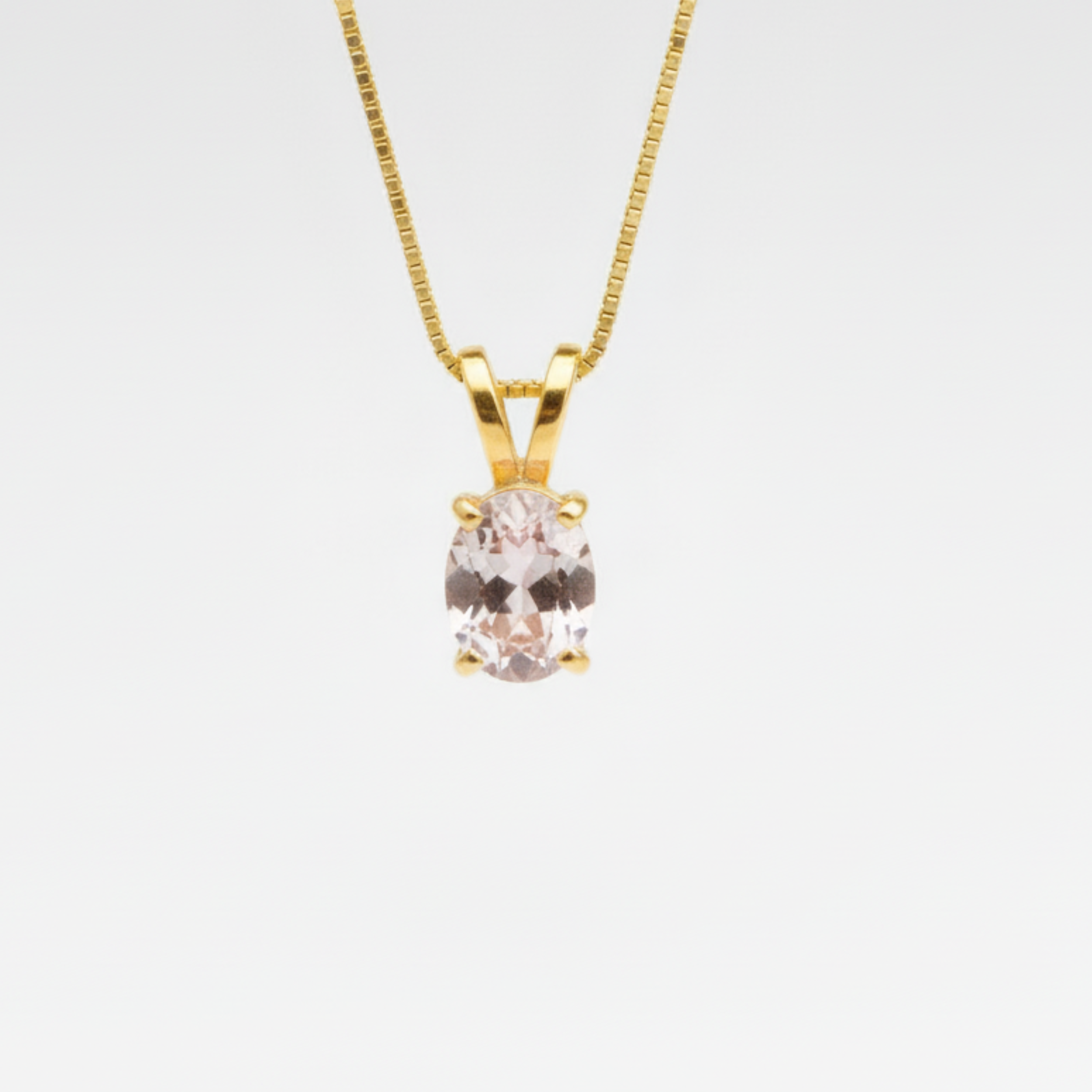 A close-up of a delicate gemstone necklace resting on a soft fabric background, showcasing intricate details and colors.