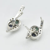 An elegant woman smiling while wearing a stunning Adina Stone necklace, showcasing its intricate design against a soft background.