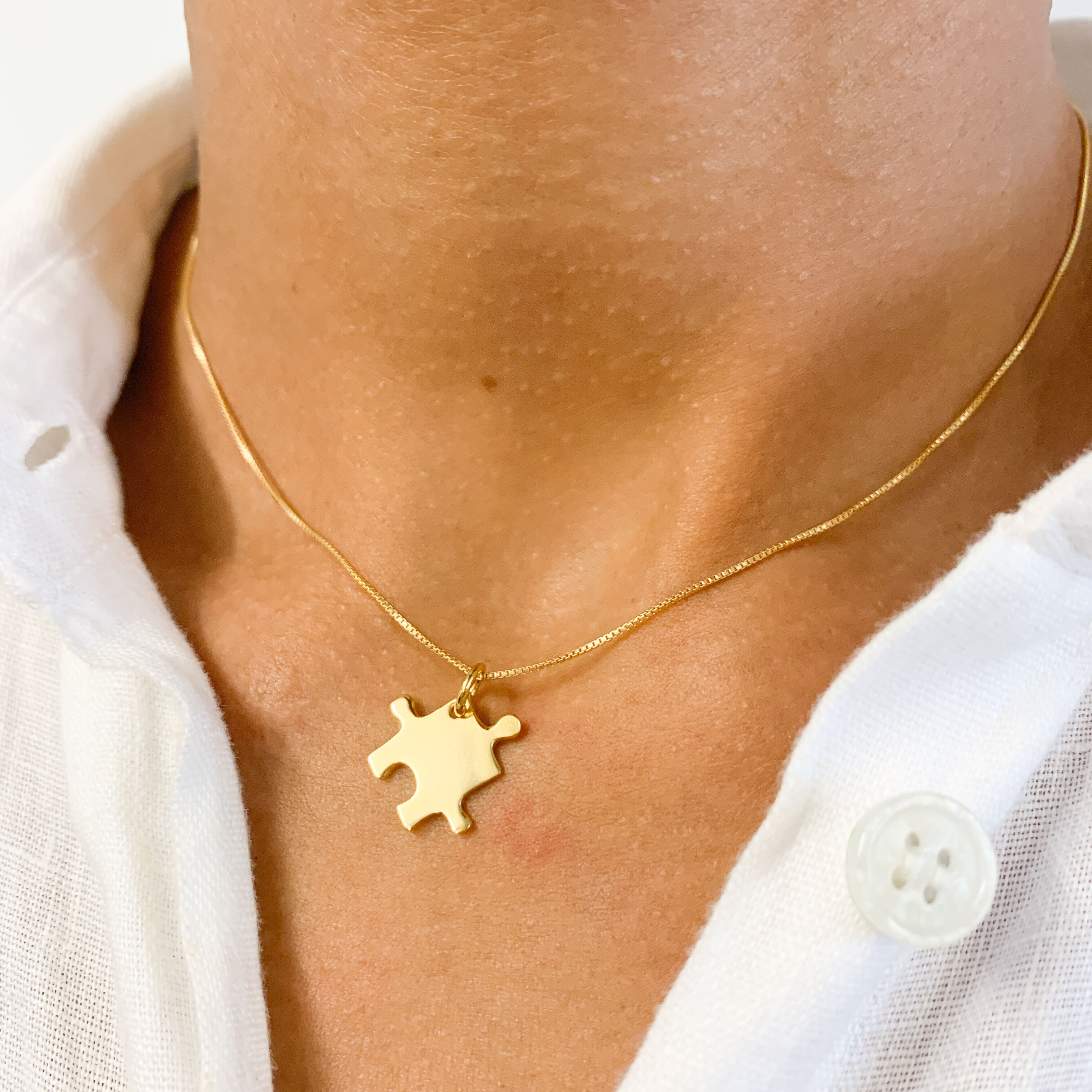Closer Shot of Gold Puzzle Necklace worn by a Model