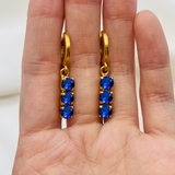 Elegant Sapphire Earrings in 18k Gold Vermeil, featuring three round created blue sapphires—perfect for September birthdays.