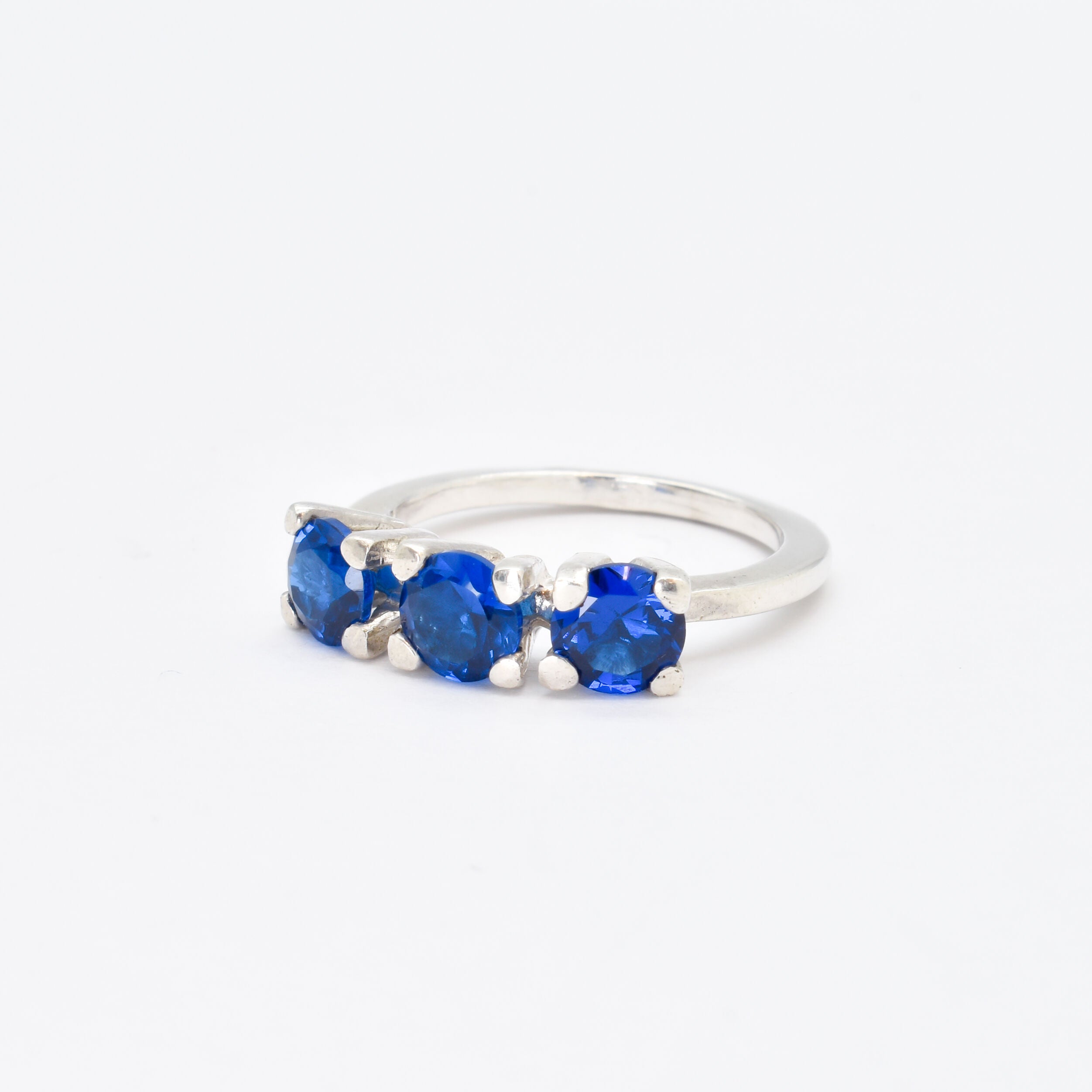 Stylish three-stone sterling silver ring with a vibrant round Created Blue Sapphire, ideal for gifting and daily wear.