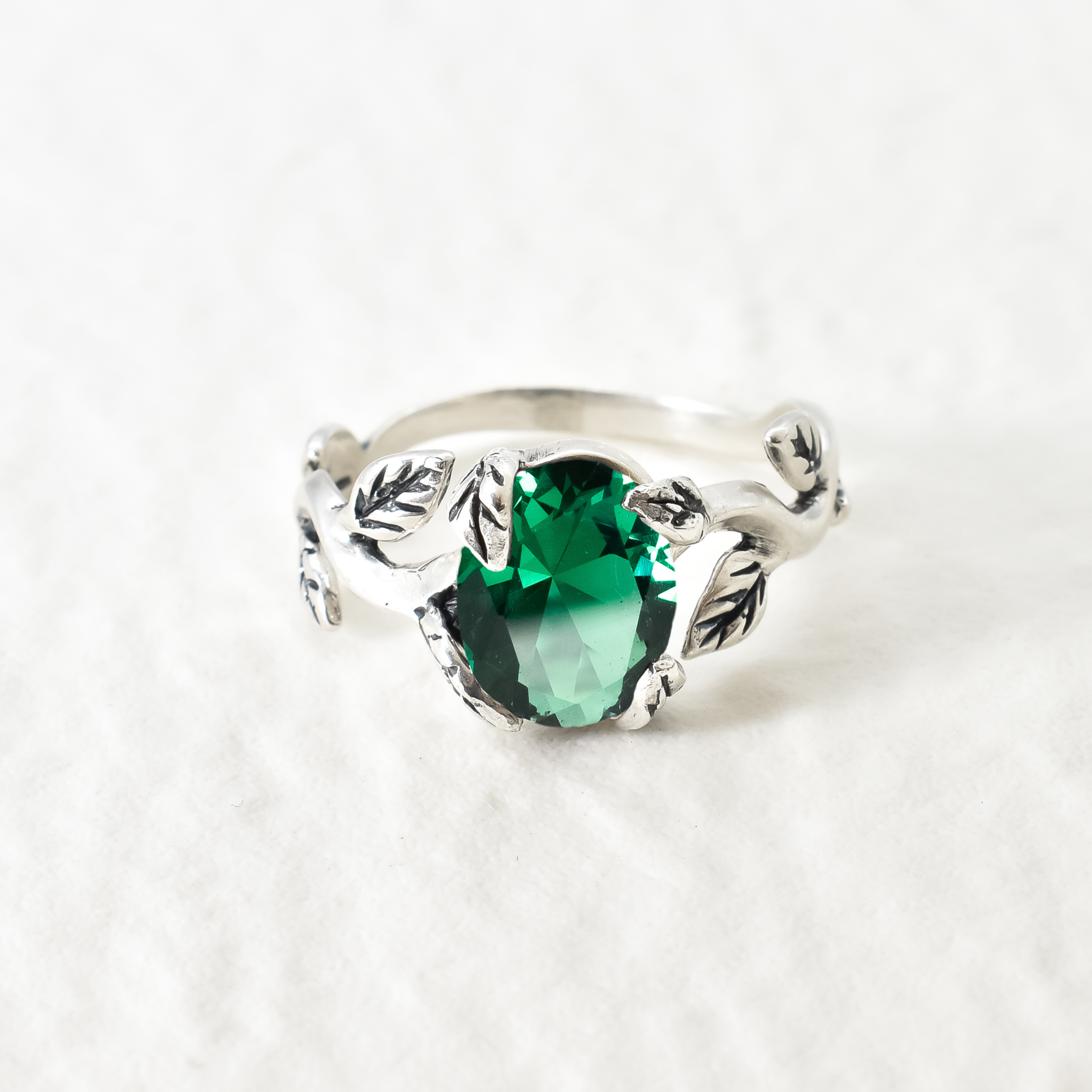 Beautiful oval created emerald in a unique prong setting, crafted in 925 Sterling Silver for a timeless look.