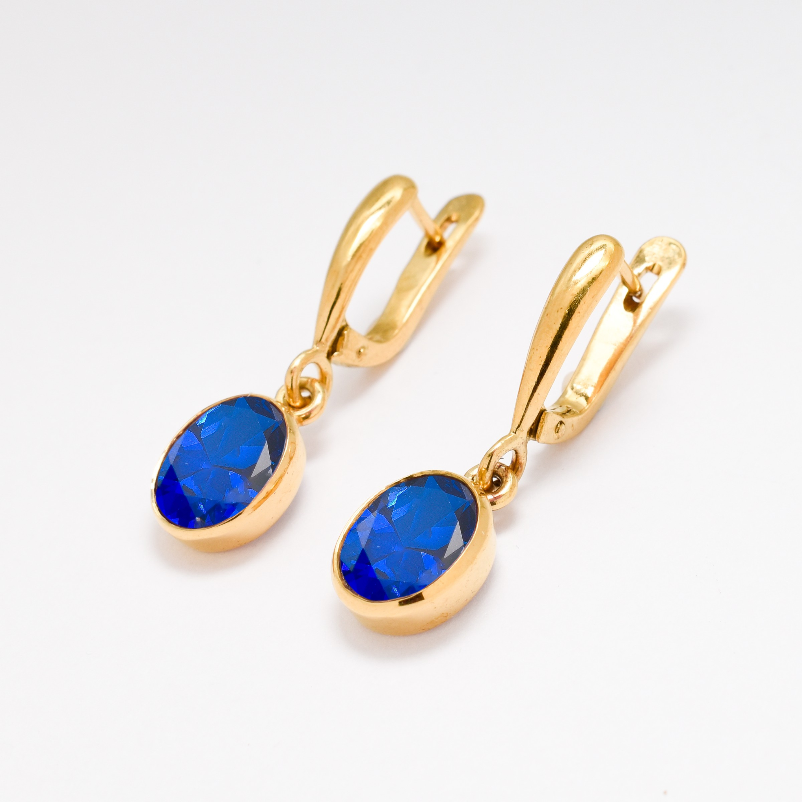 Sapphire Earrings crafted in 18k Gold Vermeil with an oval Blue Sapphire, symbolizing sincerity and perfect for special occasions.