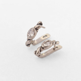 Side view of silver white topaz huggie earrings with hinged closures, oval 6x4mm clear gemstones and antique-inspired rope detail, suited to weddings, anniversaries and gifting; white topaz symbolizes focus and calm.