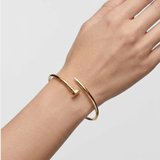 Close-up of slim open nail cuff in 18k gold vermeil worn on wrist — minimalist everyday bangle.