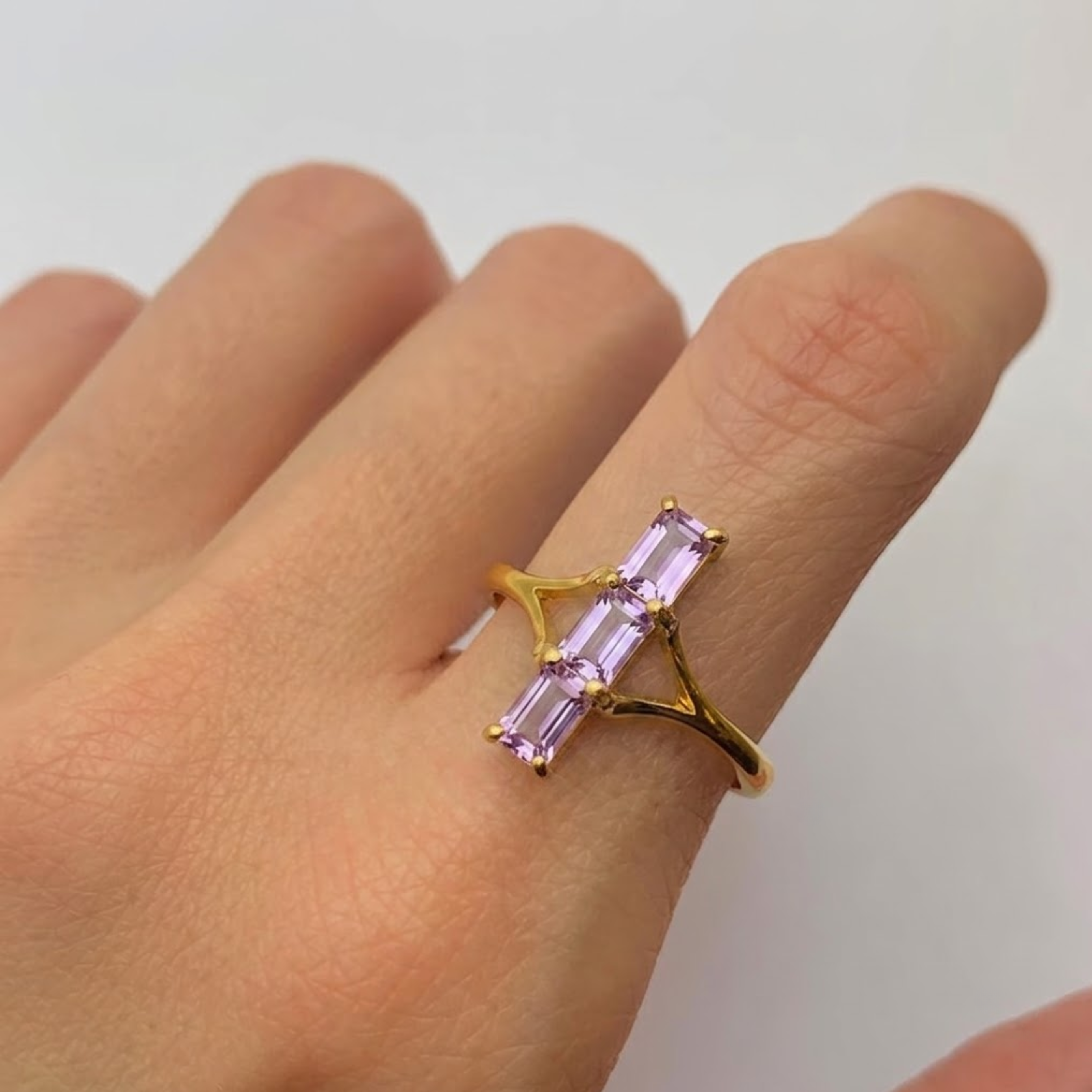 Close-up of amethyst baguette three-stone trilogy ring in 18k gold vermeil, purple February birthstone cocktail ring