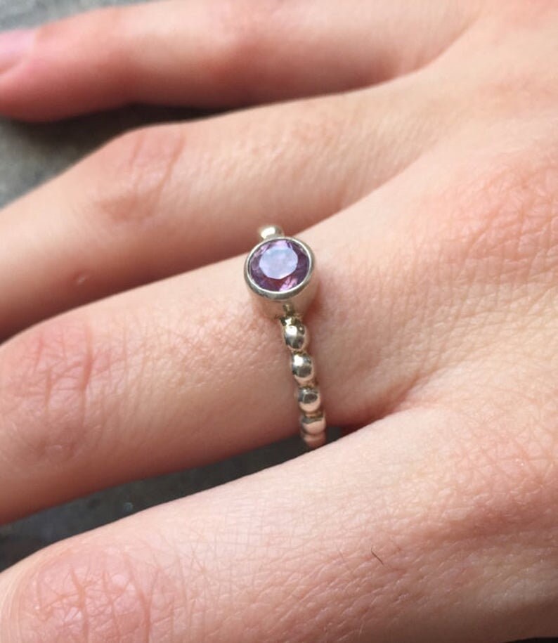 Amethyst Ring worn on middle finger with bare nails in a bubble band design, perfect for adding calm elegance to the outfit. This sterling silver tennis ring style enhances confidence and balance, making it ideal for office days, coffee meetups, and casual outings.