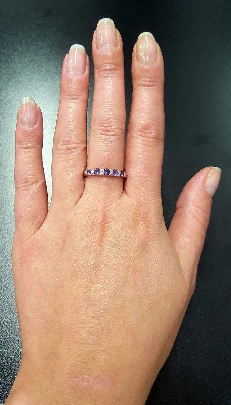 Amethyst Half Eternity Ring worn with light pink manicure, sterling silver row design that adds elegance and dainty charm, meaningful February birthstone for protection and clarity, suitable for date nights, weddings, and milestone celebrations.