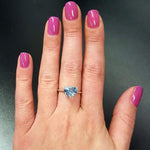 Heart Aquamarine March birthstone Ring in 18k Yellow Gold over Solid 925 Sterling Silver, in a prong setting and stunning blue color, worn on a finger for size reference. Blue gemstone solitaire ring that complements vibrant nail polish.