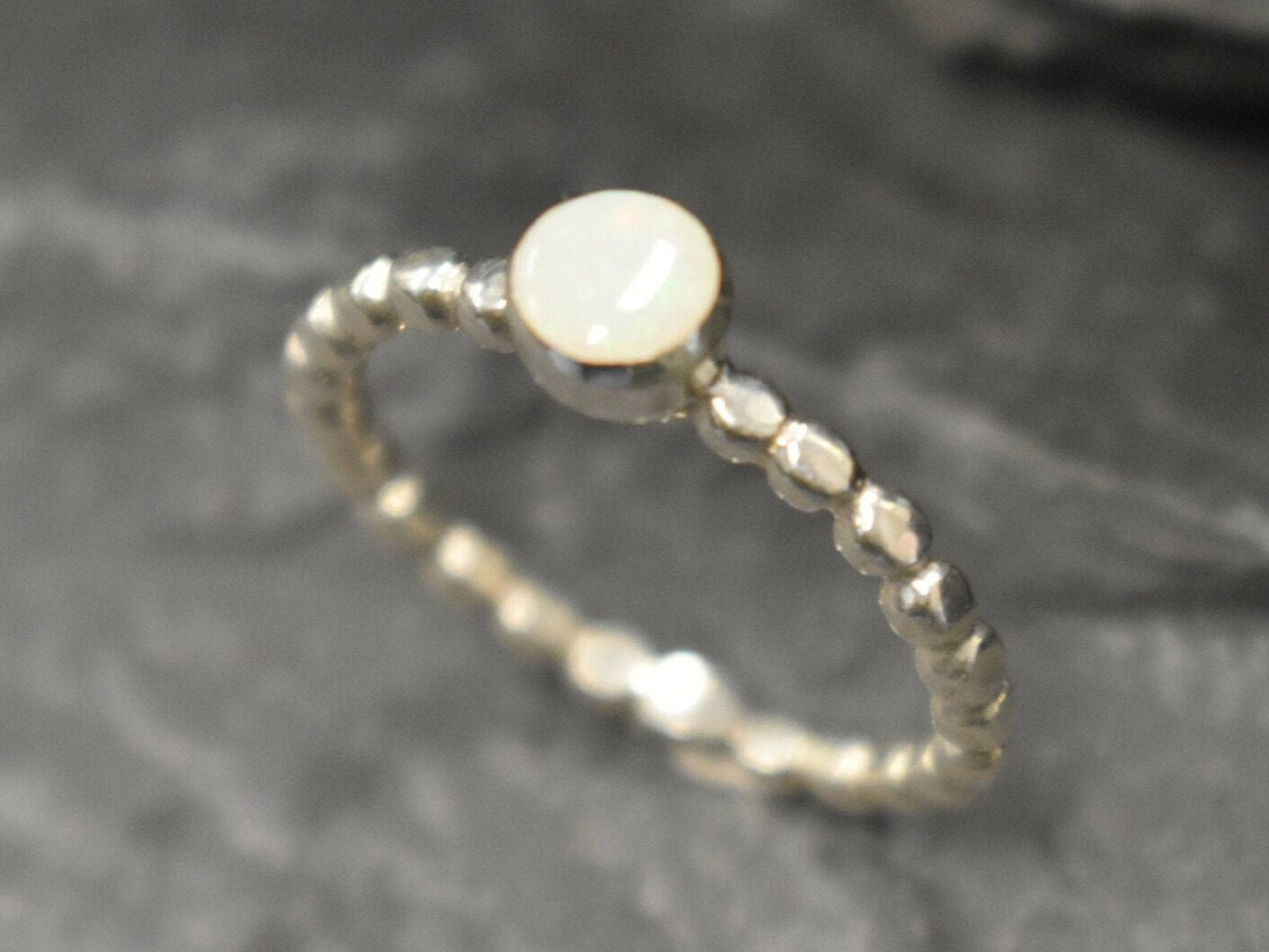 Australian White Opal bezel bubble band ring in sterling silver with round cabochon cut and flashes of fire colors, a chic jewelry style perfect for stacking and minimal elegance. Offers the benefit of a secure bezel set design with playful bubble band details, making it an ideal October birthstone gift. Perfect for birthdays, anniversaries, weddings, or everyday wear.