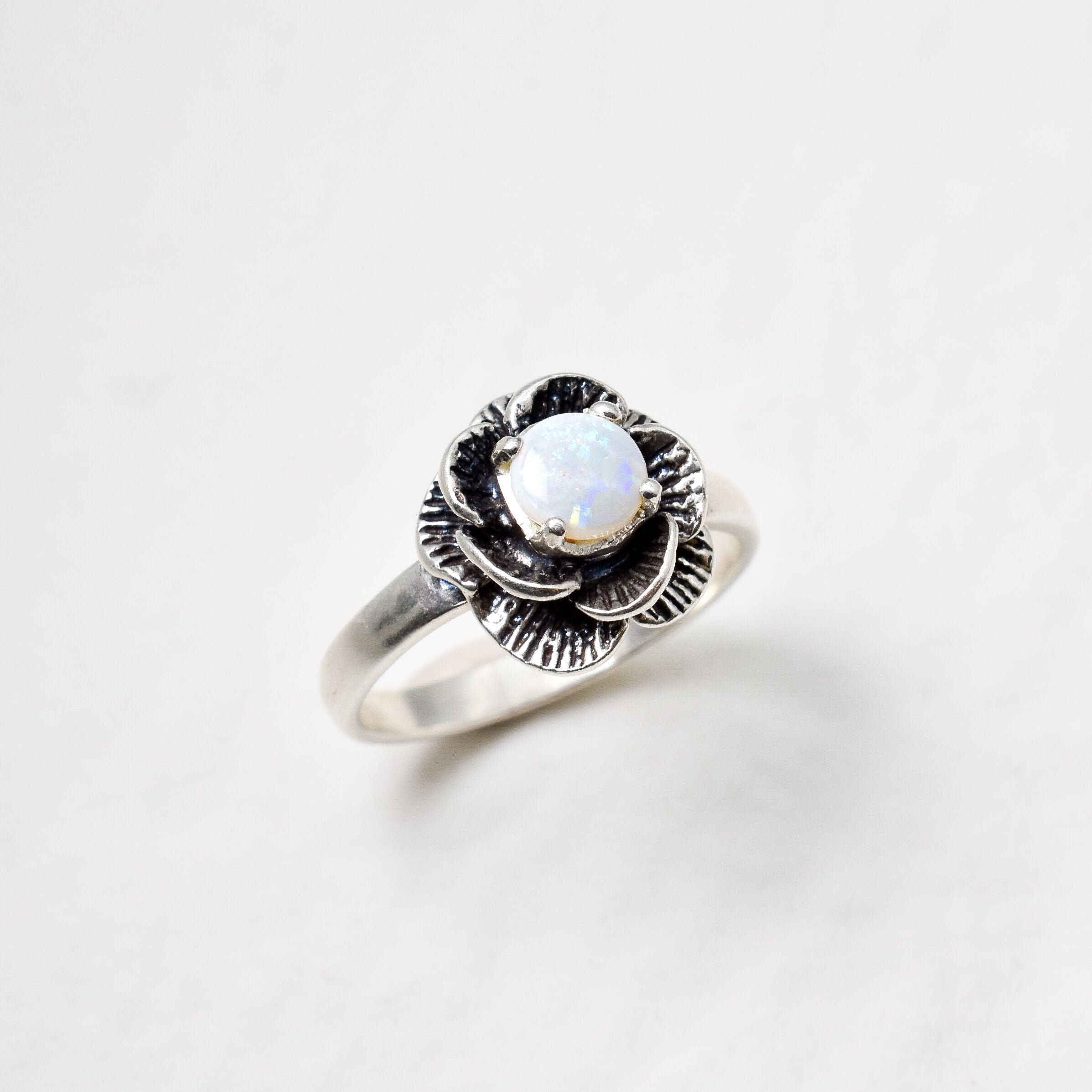 Natural Opal Flower design set in sterling silver ring offering timeless elegance and calming energy perfect as an October birthstone gift for birthdays anniversaries or romantic proposals.