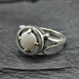 Australian Opal Ring in sterling silver featuring a round cabochon cut opal with flashes of fire colors. Australian opal is linked to creativity, inspiration, and emotional balance, making it a meaningful October birthstone gift. A thoughtful choice for birthdays, anniversaries, engagements, or promise rings. Perfect for daily wear, weddings, and elegant evening occasions.