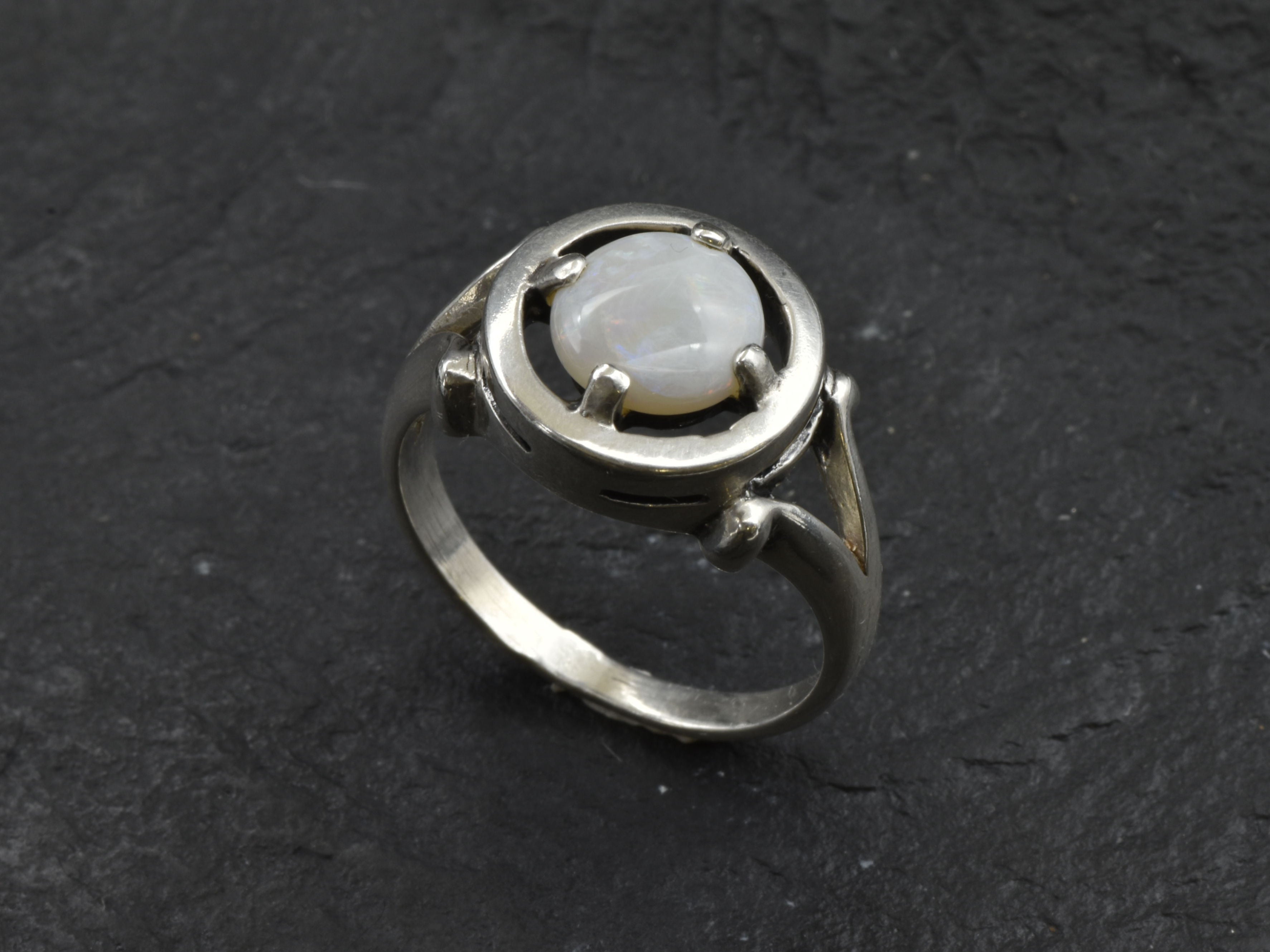 Australian Opal Ring in sterling silver featuring a round cabochon cut opal with flashes of fire colors. Australian opal is linked to creativity, inspiration, and emotional balance, making it a meaningful October birthstone gift. A thoughtful choice for birthdays, anniversaries, engagements, or promise rings. Perfect for daily wear, weddings, and elegant evening occasions.