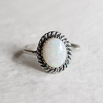 Natural Australian Opal sterling silver ring with an oval cabochon cut gemstone framed by a detailed rope-edge design, offering a timeless and elegant style. Opal, the October birthstone, is valued for enhancing creativity and emotional harmony, making it an ideal gift for birthdays, anniversaries, weddings, and milestone celebrations.