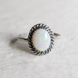 Natural Australian Opal sterling silver ring with an oval cabochon cut gemstone framed by a detailed rope-edge design, offering a timeless and elegant style. Opal, the October birthstone, is valued for enhancing creativity and emotional harmony, making it an ideal gift for birthdays, anniversaries, weddings, and milestone celebrations.