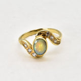 Vintage Opal Ring in a bezel set gold wave design with flashes of rainbow and fire colors, accented by sparkling CZ Diamonds on each curve. Opal is believed to inspire creativity, hope and emotional balance, making it a meaningful October birthstone gift for anniversaries, engagements, weddings and special celebrations.