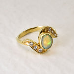 Vintage Opal Ring in a bezel set gold wave design with flashes of rainbow and fire colors, accented by sparkling CZ Diamonds on each curve. Opal is believed to inspire creativity, hope and emotional balance, making it a meaningful October birthstone gift for anniversaries, engagements, weddings and special celebrations.