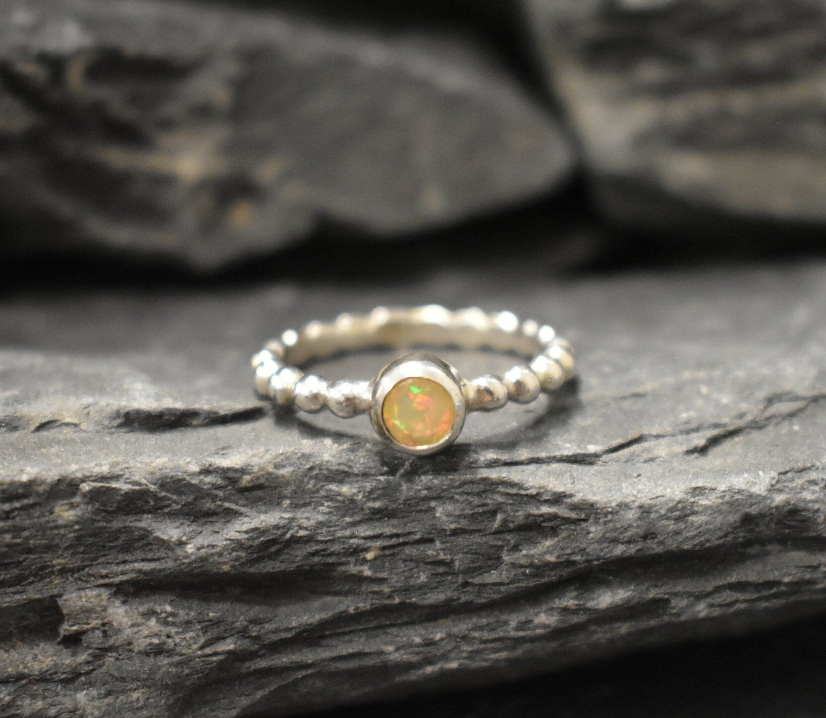 Yellow Fire Opal Bubble Band Ring in sterling silver with bezel set round cut, showcasing flashes of fire colors in a tennis band design for an elegant jewelry style. This durable and timeless piece is a meaningful October birthstone gift idea, symbolizing passion and inspiration. Ideal for birthdays, weddings, anniversaries, and evening occasions where a touch of unique brilliance is desired.