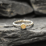 Yellow Fire Opal Bubble Band Ring in sterling silver with bezel set round cut, showcasing flashes of fire colors in a tennis band design for an elegant jewelry style. This durable and timeless piece is a meaningful October birthstone gift idea, symbolizing passion and inspiration. Ideal for birthdays, weddings, anniversaries, and evening occasions where a touch of unique brilliance is desired.