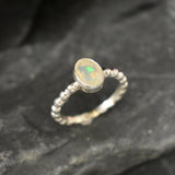 Fire Opal bezel bubble band ring in sterling silver with flashes of fire colors, a dainty jewelry style perfect for everyday elegance and stacking. Offers the benefit of durability with bezel setting and a glowing October birthstone gift idea for loved ones. Ideal to wear for birthdays, anniversaries, engagements, or casual celebrations.