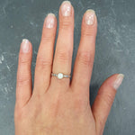 Opal Engraved Ring styled on hand with nude nails. The minimalist bezel design pairs with engraved tribal details for a boho chic look. The gemstone reflects flashes of color, symbolizing harmony and balance. A meaningful promise ring or birthday gift. Suitable for everyday wear, romantic dinners, or weddings.